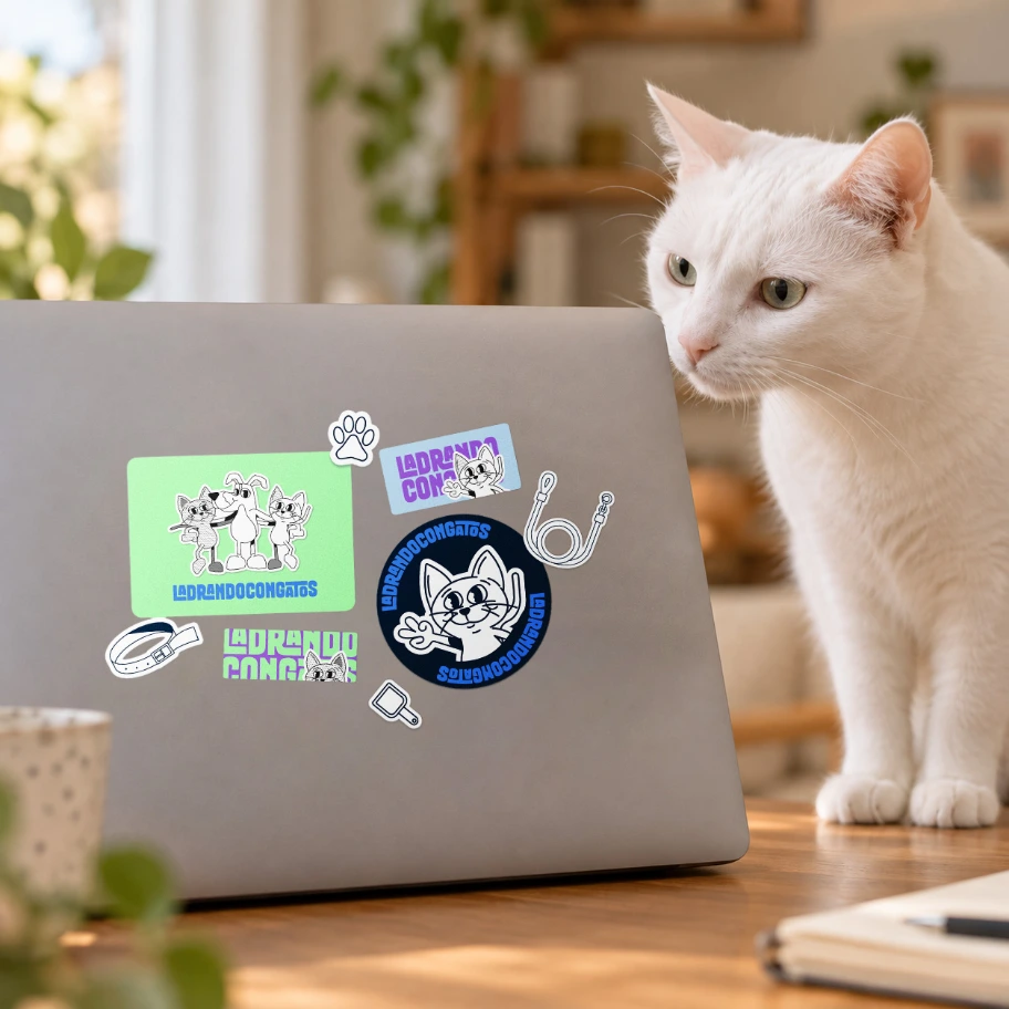 Pegatinas de LadrandoConGatos en un portátil, con un gato mirando