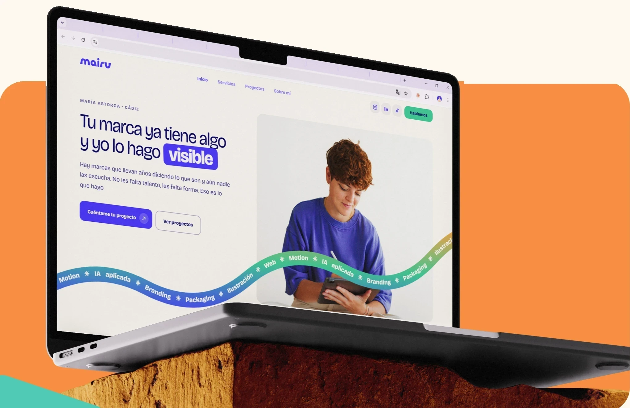 Diseño web de Mairu Studio en un portátil, con el logotipo y las ilustraciones de la marca