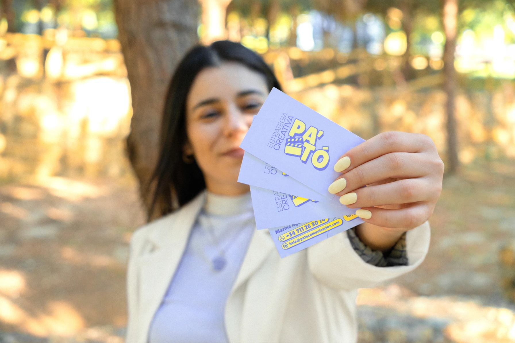 Marina mostrando las tarjetas de visita de PA'TÓ Comunicación, diseño de papelería por Mairu Studio